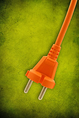 Image showing orange electrical plug on  green background