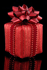 Image showing red gift on black background 