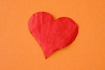 Image showing paper heart on the orange background