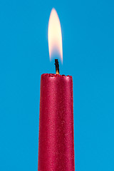 Image showing Burning candle over a blue background