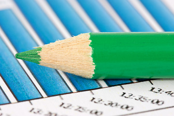 Image showing green pencil on financial graphs