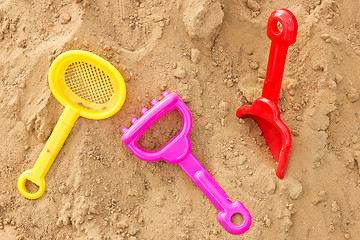 Image showing color plastic toys on a sand