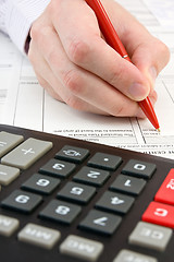 Image showing calculator,documents and  hand with pen