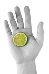 Image showing human hand with a green lemon