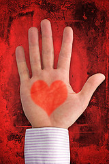 Image showing hand with heart shape on dark red background