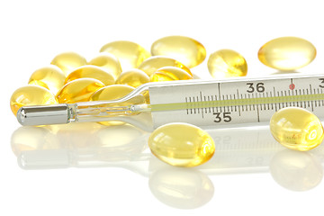 Image showing medical thermometer and yellow pills 