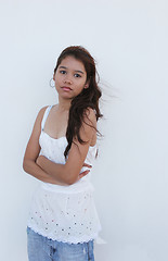 Image showing Asian girl standing in front of a white wall