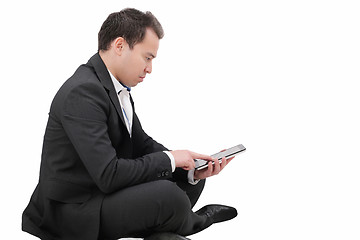 Image showing Young man sitting on a floor and using tablet pc 