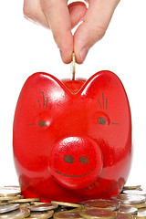 Image showing hand putting coin into the piggy bank