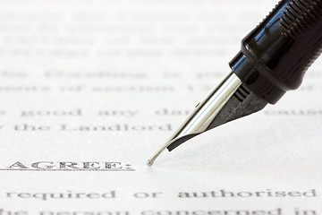 Image showing ink pen over a printed agreement