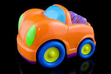 Image showing orange plastic car on black