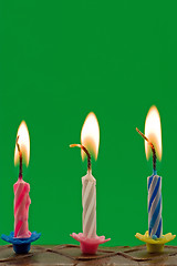 Image showing candles in a cake, over a green background
