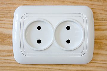 Image showing white electric outlet on wooden wall