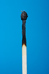 Image showing burnt match stick isolated on blue