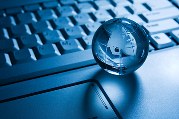 Image showing transparent globe on a laptop  keyboard 