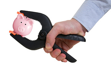 Image showing businessman squeezing piggy bank in a clamp