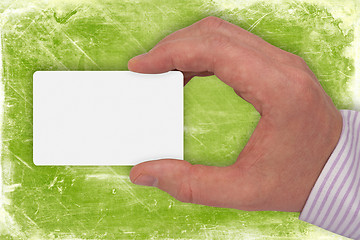 Image showing hand with white card on green background