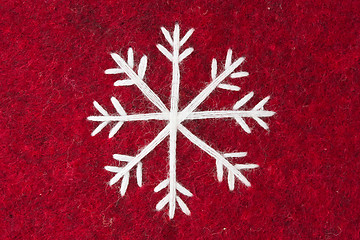 Image showing red felt with embroidered white snowflake