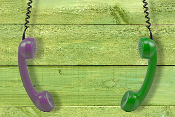 Image showing handsets hung against wooden wall