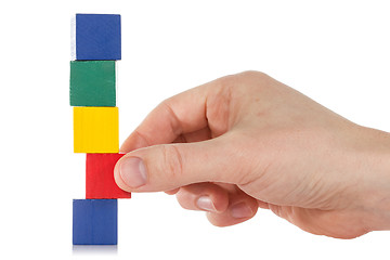Image showing Hand establishes a wooden cube