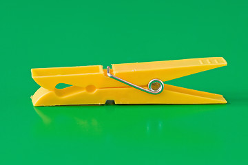 Image showing yellow plastic clothespin  on green background
