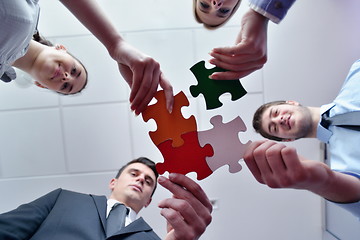 Image showing Group of business people assembling jigsaw puzzle