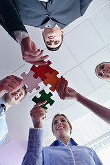 Image showing Group of business people assembling jigsaw puzzle