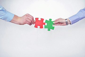 Image showing Group of business people assembling jigsaw puzzle