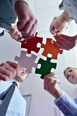 Image showing Group of business people assembling jigsaw puzzle