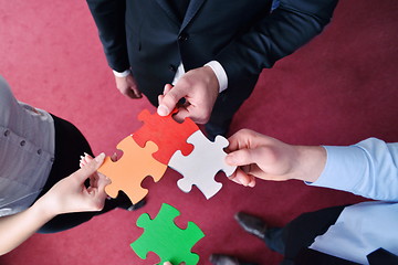 Image showing Group of business people assembling jigsaw puzzle