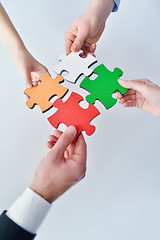 Image showing Group of business people assembling jigsaw puzzle