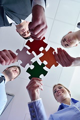 Image showing Group of business people assembling jigsaw puzzle