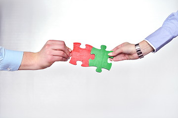 Image showing Group of business people assembling jigsaw puzzle