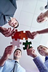 Image showing Group of business people assembling jigsaw puzzle