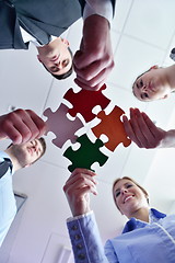 Image showing Group of business people assembling jigsaw puzzle