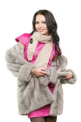 Image showing smiling young brunette in a fur coat