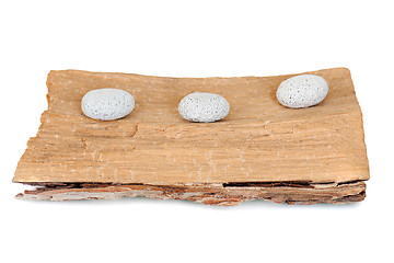 Image showing three stones on a grunge wood isolated on white background