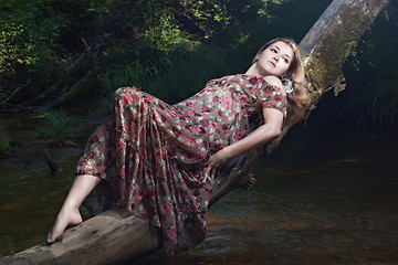 Image showing Beautiful girl in the national dress and hat stand in the river 