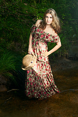 Image showing Beautiful girl in the national dress and hat stand in the river 