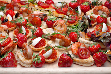 Image showing Lot of canape with  shrimp, caviar, strawberries and other on wo