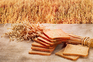Image showing loaf of rye bread on a background of ripe rye field at sunset