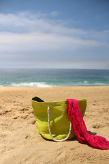 Image showing Green beach bag on the seacoast and pink shawl  