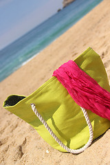 Image showing Green beach bag on the seacoast and pink shawl  