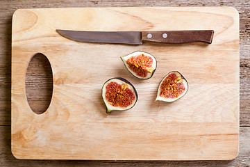 Image showing figs and old knife on wooden board