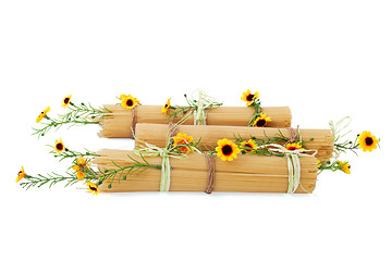 Image showing Uncooked Italian spaghetti decorated with yellow flowers isolate