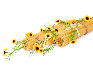 Image showing Uncooked Italian spaghetti decorated with yellow flowers isolate