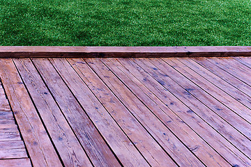 Image showing Fresh spring green grass with wood floor 