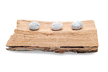 Image showing Three stones on a grunge wood isolated on white