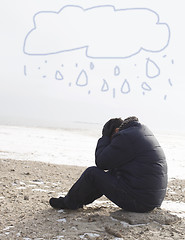 Image showing Lonely man sitting on sand