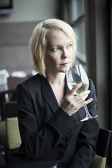 Image showing Blonde Woman with Beautiful Blue Eyes Drinking Glass of White Wi